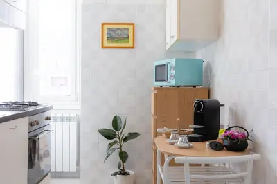 a kitchen with a small table with a blue microwave at Cherry Suites- Timeless Roman Residence & Terrace in Rome