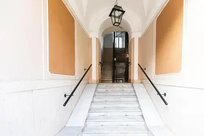 a hallway of a building with a black door at Cherry Suites- Timeless Roman Residence & Terrace in Rome