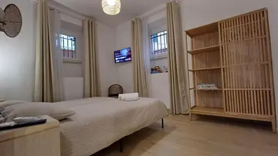 a bedroom with a bed and a tv and two windows at Mimmi's house in Rome