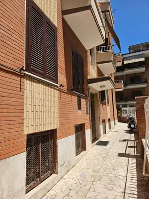 an empty alley with a brick building with closed gates at La Casa di Fede in Rome