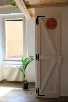 a sliding barn door in a room with a clock at Epirhome, tra Colosseo e Porta Santa in Rome