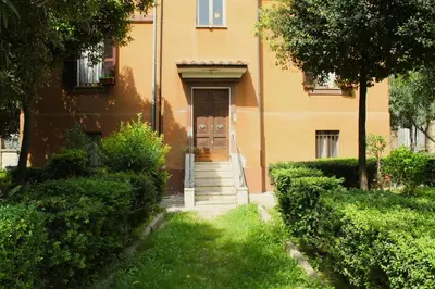a yellow building with a door and stairs in a yard at Epirhome, tra Colosseo e Porta Santa in Rome