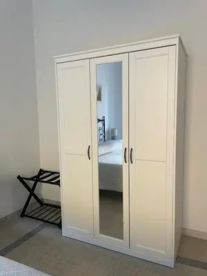 a white cabinet with a mirror in a bedroom at Casa vacanza Brandi in Rome