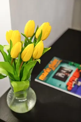 a vase filled with yellow flowers on a table at Leopardo Boutique Apartment in Trastevere in Rome