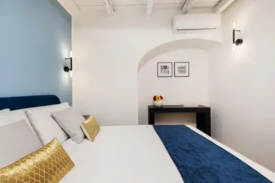 a bedroom with a white bed and a table at Leopardo Boutique Apartment in Trastevere in Rome