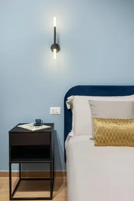 a bed with a night stand next to a side table at Leopardo Boutique Apartment in Trastevere in Rome