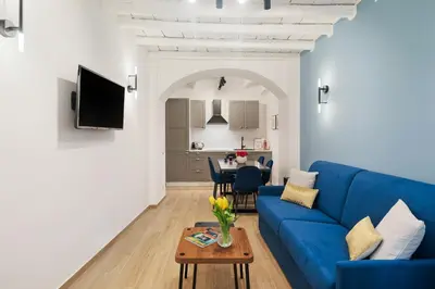 a living room with a blue couch and a table at Leopardo Boutique Apartment in Trastevere in Rome