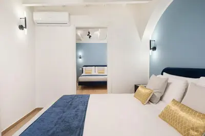 a bedroom with a large white bed and a room with a bedicterictericter at Leopardo Boutique Apartment in Trastevere in Rome