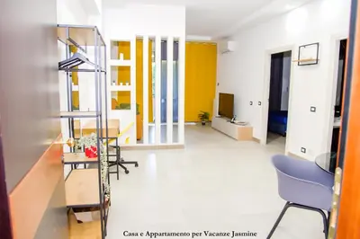 a room with yellow and white walls and a blue chair at Casa e Appartamento per Vacanze JASMINE in Rome