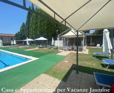 a pool with an umbrella and chairs and a swimming pool at Casa e Appartamento per Vacanze JASMINE in Rome