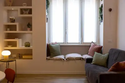 a living room with a couch and two windows at DaliTourism - La Casa di Pida Vatican Apartment in Rome