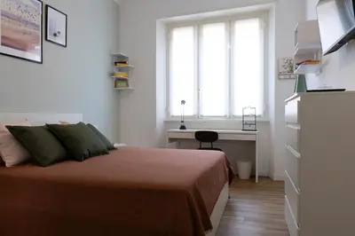 a bedroom with a bed and a desk and a window at DaliTourism - La Casa di Pida Vatican Apartment in Rome