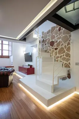 a living room with a staircase with a stone wall at Pantheon Luxury Apartment in Rome