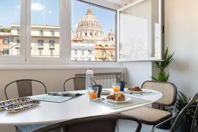 a white table with two plates of food and a building at Vatican Loft - San Pietro in Rome