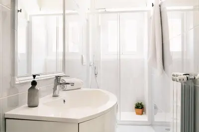 a white bathroom with a sink and a shower at Vatican Loft - San Pietro in Rome
