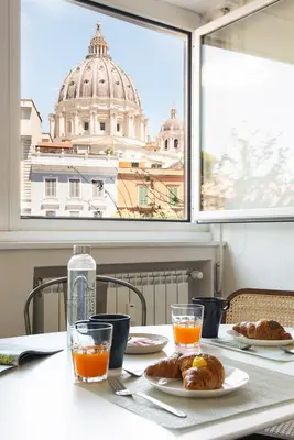 a table with two plates of pastries and a large window at Vatican Loft - San Pietro in Rome