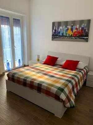 a bedroom with a large bed with red pillows at La Casa di Léon - Battistini - Vaticano in Rome