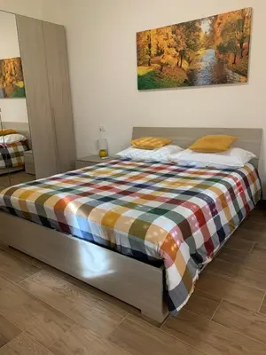 a bed in a bedroom with a painting on the wall at La Casa di Léon - Battistini - Vaticano in Rome