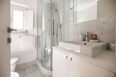 a white bathroom with a sink and a shower at Crystal Home Piazza Navona in Rome