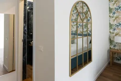 a mirror on the wall of a room with a bed at Appartamento con 2 camere e 2 bagni -San Giovanni- in Rome