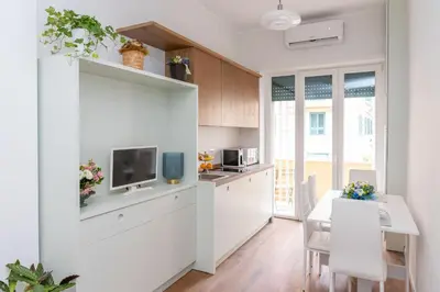 a kitchen with white cabinets and a table with a tv at Appartamento con 2 camere e 2 bagni -San Giovanni- in Rome