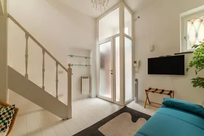 a living room with a blue couch and a tv at GuestHost - Piazza de' Renzi Duplex Apartment in Rome