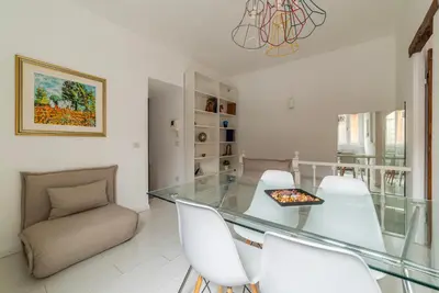 a dining room with a glass table and white chairs at GuestHost - Piazza de' Renzi Duplex Apartment in Rome