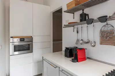 a kitchen with white cabinets and a red appliance at GuestHost - Piazza de' Renzi Duplex Apartment in Rome