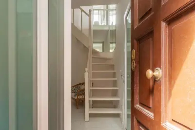 a spiral staircase in a room with a door at GuestHost - Piazza de' Renzi Duplex Apartment in Rome