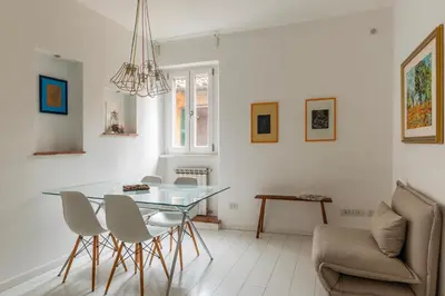 a dining room with a glass table and chairs at GuestHost - Piazza de' Renzi Duplex Apartment in Rome