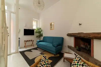 a living room with a blue couch and a tv at GuestHost - Piazza de' Renzi Duplex Apartment in Rome