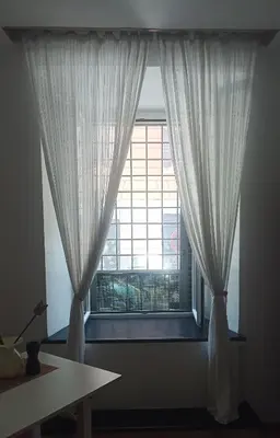 a window with white curtains in a room at Famy in Rome