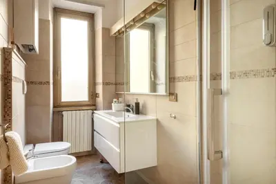 a bathroom with a toilet and a sink and a mirror at Apartment27 Roma in Rome