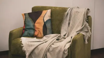 two pillows on a green couch with a blanket at TIBERIM Exclusive Rome in Rome