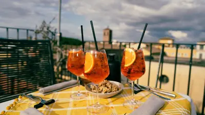 a table with three wine glasses with orange slices in them at TIBERIM Exclusive Rome in Rome