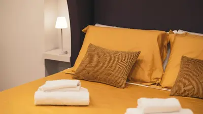 a bed with two towels and two pillows on it at TIBERIM Exclusive Rome in Rome
