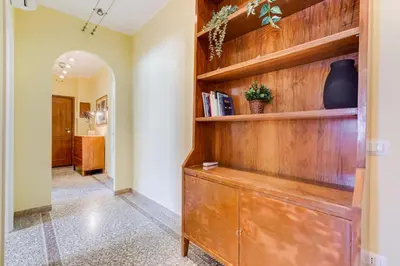 a hallway with a wooden book shelf at The Pope's Oasis near Trastevere and Historical Center in Rome