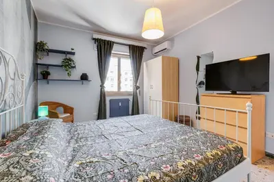 a bedroom with a bed and a flat screen tv at The Pope's Oasis near Trastevere and Historical Center in Rome