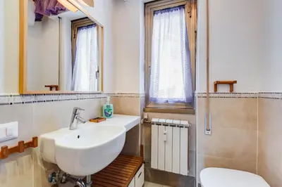 a bathroom with a sink and a toilet and a mirror at The Pope's Oasis near Trastevere and Historical Center in Rome