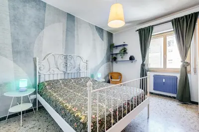 a bedroom with a white bed with a floral bedspread at The Pope's Oasis near Trastevere and Historical Center in Rome