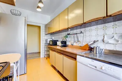 a kitchen with yellow cabinets and a white refrigerator at The Pope's Oasis near Trastevere and Historical Center in Rome