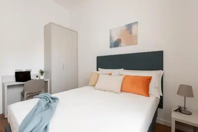 a bedroom with a large white bed with orange and white pillows at Elegant Haven Re di Roma by Hostand in Rome