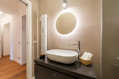 a bathroom with a sink and a mirror on the wall at Elegant Haven Re di Roma by Hostand in Rome