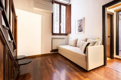 a living room with a white couch and wooden floors at Navona in Love in Rome