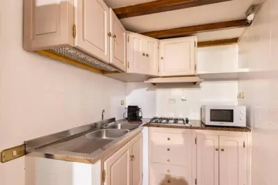 a kitchen with white cabinets and a sink and a microwave at Navona in Love in Rome