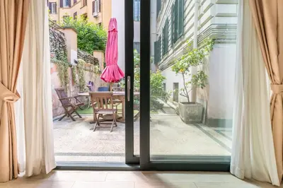 an open door to a patio with a table and an umbrella at Flaminio Garden, Indenpent Flat 10 min from the City Center in Rome