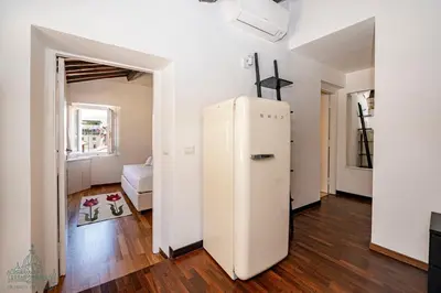 a white refrigerator in a room with a bedroom at Domus in Lauro in Rome
