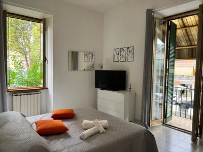 a bedroom with a bed with orange pillows and a television at Home Rome in Rome