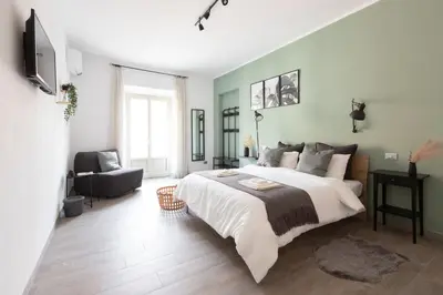 a bedroom with a large bed and a chair at Maison Margaret in Rome