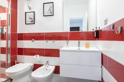 a red and white bathroom with a toilet and sink at Maison Margaret in Rome